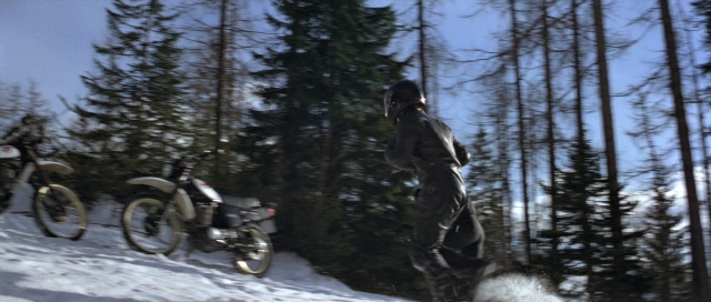 Wide shot frame from For Your Eyes Only — hat, bicycle, forest