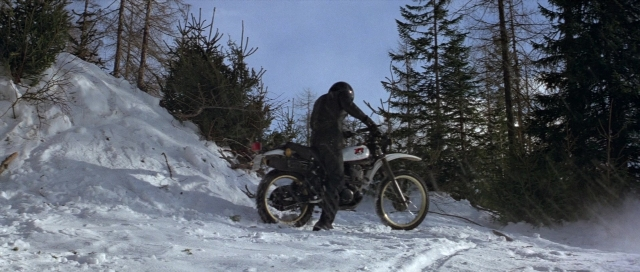 Wide shot frame from For Your Eyes Only — hat, snow, motorcycle