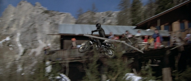 Wide shot frame from For Your Eyes Only — standing, hat, bicycle