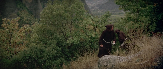 Wide shot frame from For Your Eyes Only — walking, hat, dog