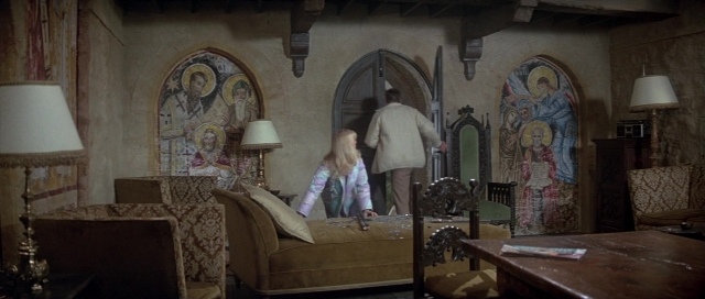 Wide shot frame from For Your Eyes Only — standing, room, table