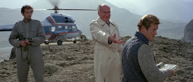 Wide shot frame from For Your Eyes Only — standing, coat, gun
