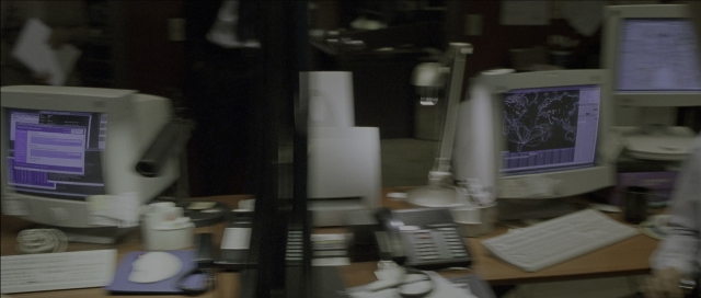 Wide shot frame from The Bourne Identity — phone, office, computer keyboard