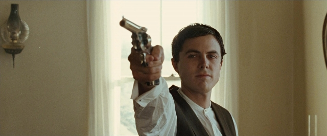 Wide shot frame from The Assassination of Jesse James by the Coward Robert Ford — standing, room, hand