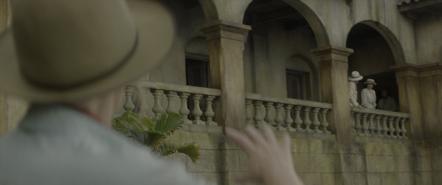 Wide shot frame from Jungle Cruise — standing, hat, hand