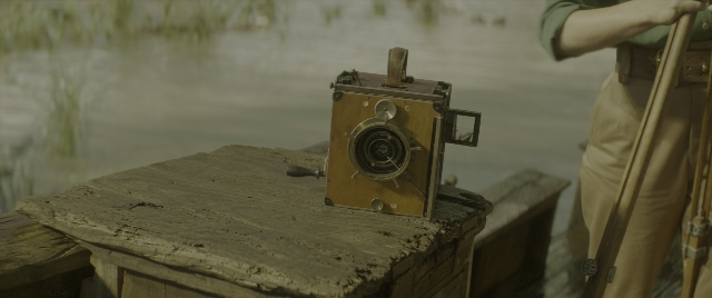 Wide shot frame from Jungle Cruise — table, hand, water
