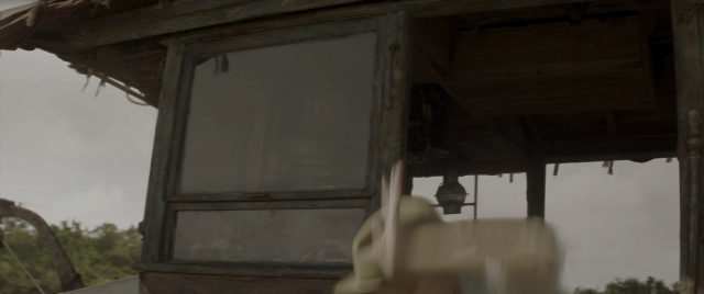 Wide shot frame from Jungle Cruise — hand, house, lamp