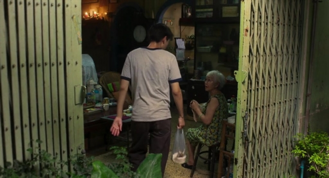 Wide shot frame from Lahn Mah — sitting, standing, walking