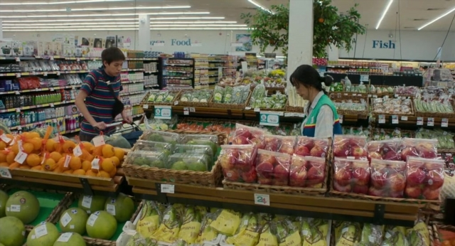 Wide shot frame from Lahn Mah — standing, food, shirt
