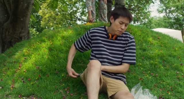 Frame from Lahn Mah — sitting, phone, shirt