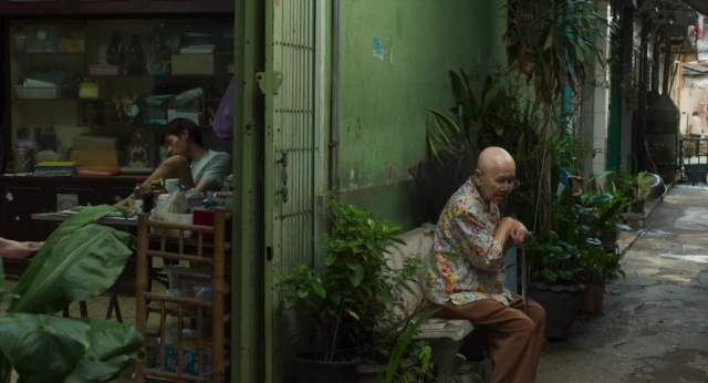 Frame from Lahn Mah — sitting, desk, door