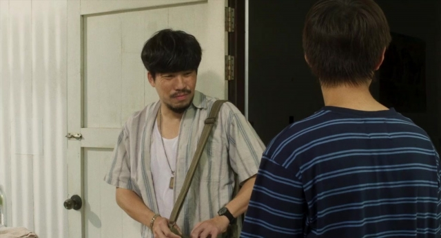 Frame from Lahn Mah — standing, room, table
