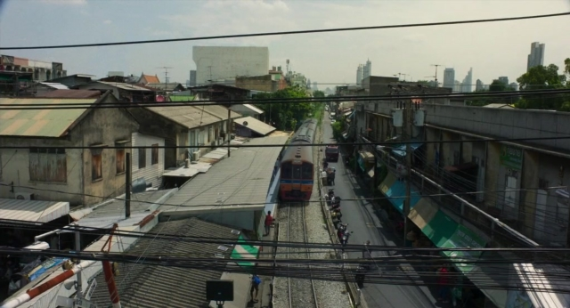 Wide shot frame from Lahn Mah — walking, street, bicycle