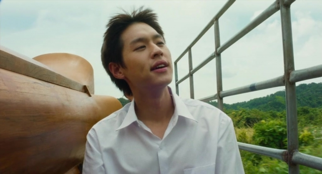 Wide shot frame from Lahn Mah — standing, shirt, face