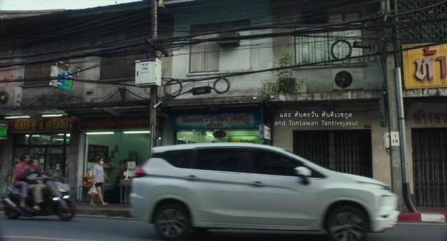 Wide shot frame from Lahn Mah — walking, street, car