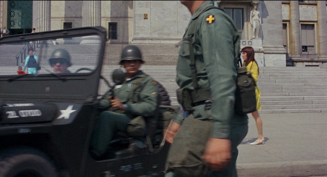 Wide shot frame from Medium Cool — standing, walking, street