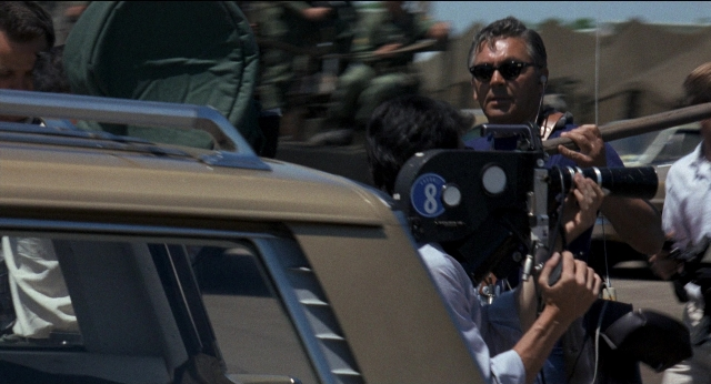 Wide shot frame from Medium Cool — standing, car, person
