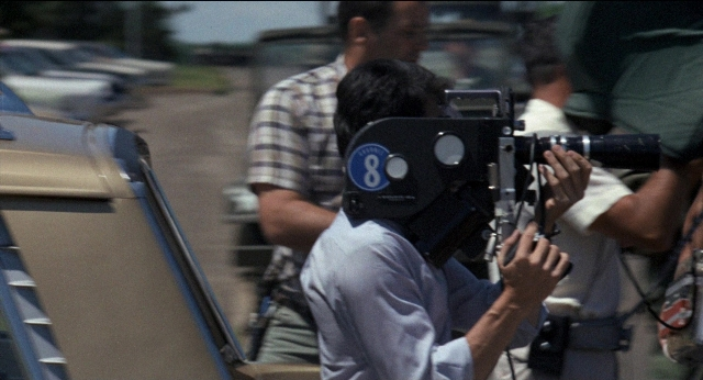 Wide shot frame from Medium Cool — shirt, camera, person