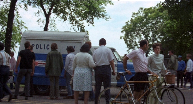Wide shot frame from Medium Cool — standing, walking, street