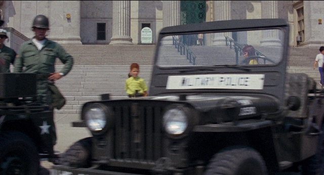Wide shot frame from Medium Cool — standing, walking, street