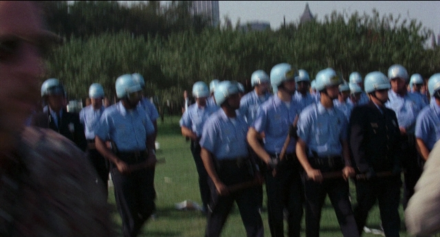 Wide shot frame from Medium Cool — standing, person, human face