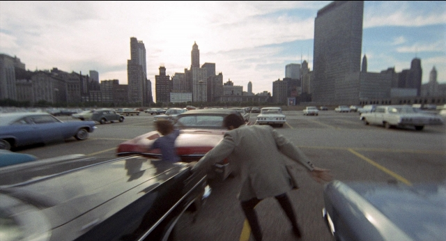 Wide shot frame from Medium Cool — walking, street, car