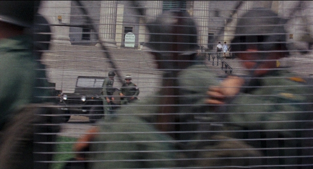 Wide shot frame from Medium Cool — standing, wheel, person