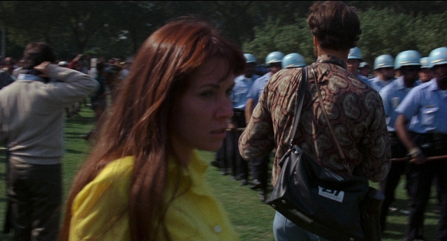 Wide shot frame from Medium Cool — standing, dialogue, hair