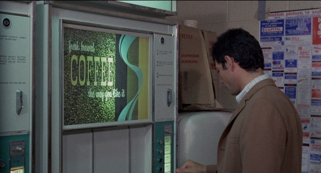 Wide shot frame from Medium Cool — standing, poster, person