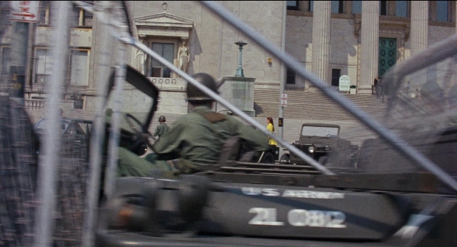 Wide shot frame from Medium Cool — street, car, person