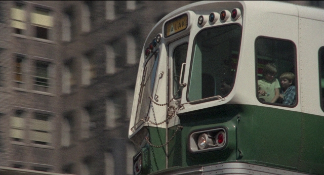 Wide shot frame from Medium Cool — sitting, street, train