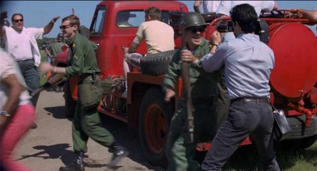 Wide shot frame from Medium Cool — gun, wheel, person