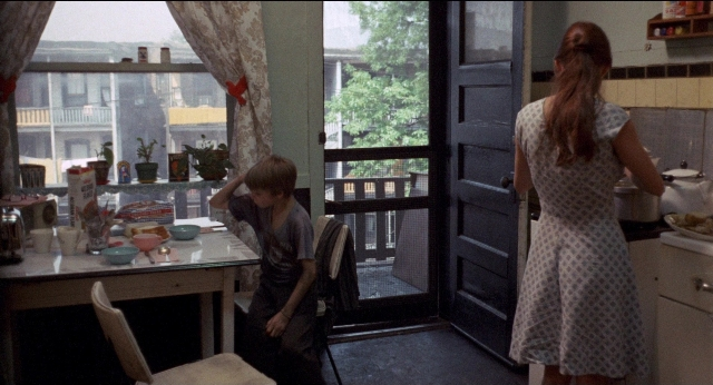 Wide shot frame from Medium Cool — sitting, standing, table