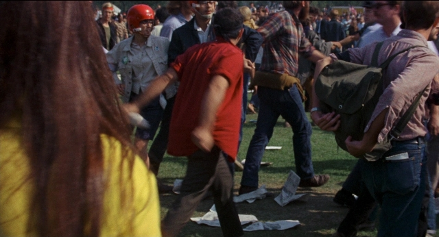 Wide shot frame from Medium Cool — hat, shirt, person