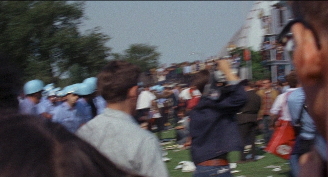 Wide shot frame from Medium Cool — standing, person, human face