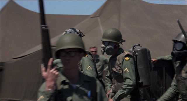 Wide shot frame from Medium Cool — standing, hat, hand