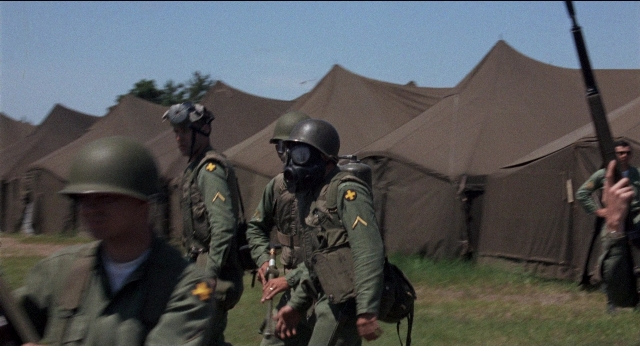 Wide shot frame from Medium Cool — walking, tent, person