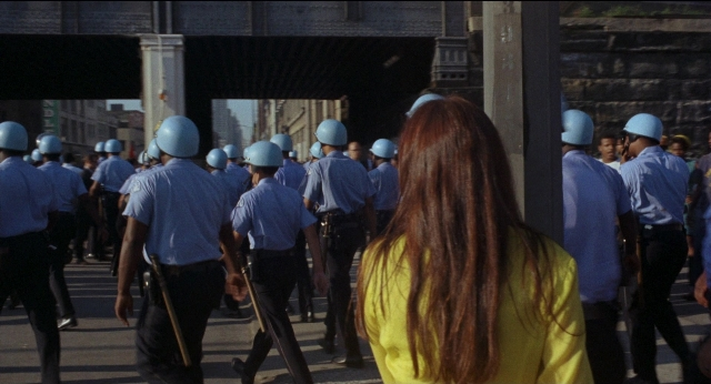 Wide shot frame from Medium Cool — walking, street, hair