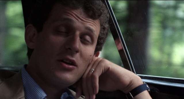 Close-up frame from Medium Cool — hand, shirt, face