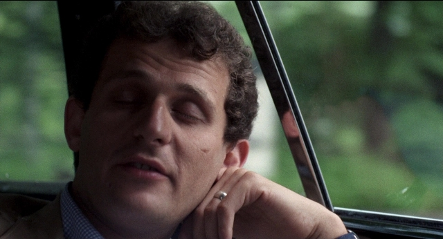 Close-up frame from Medium Cool — car, hand, suit