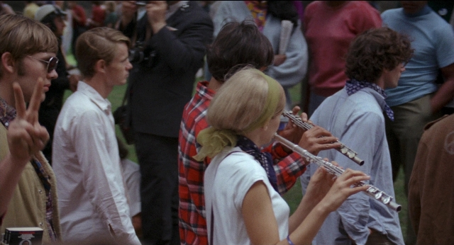 Wide shot frame from Medium Cool — standing, hand, shirt