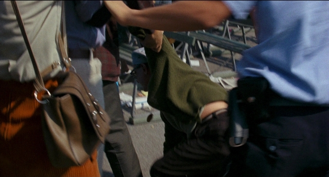 Frame from Medium Cool — hand, shirt, person