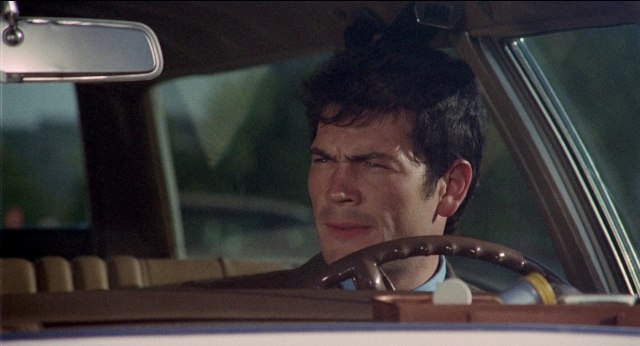 Wide shot frame from Medium Cool — sitting, street, mirror