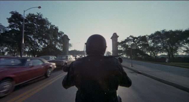 Wide shot frame from Medium Cool — street, hat, car