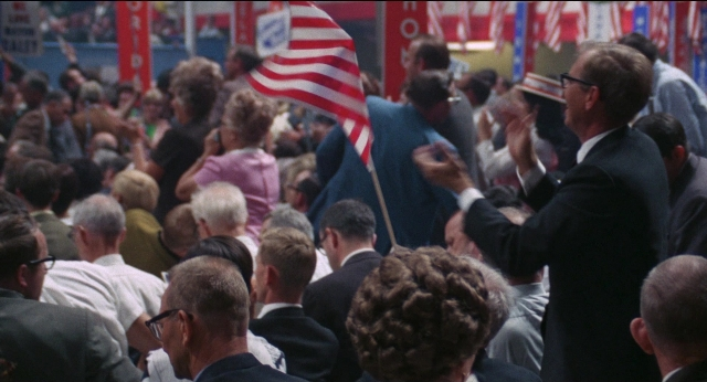 Frame from Medium Cool — standing, room, flag