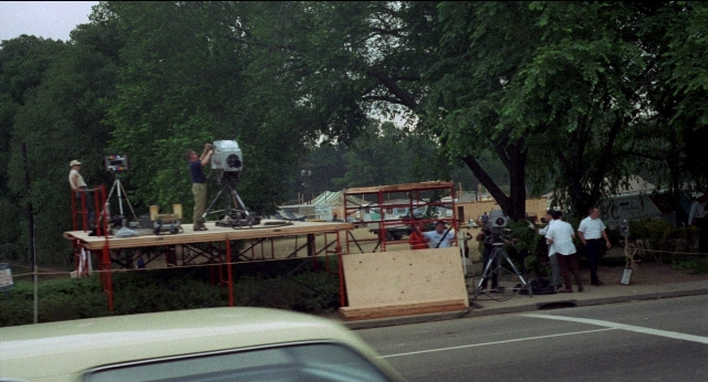 Wide shot frame from Medium Cool — standing, street, car