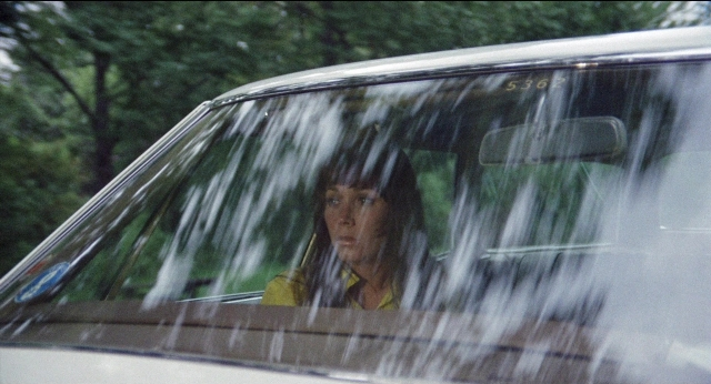 Wide shot frame from Medium Cool — sitting, street, car