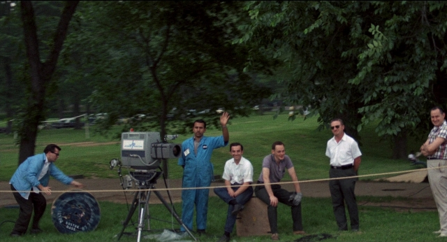 Wide shot frame from Medium Cool — sitting, standing, dialogue