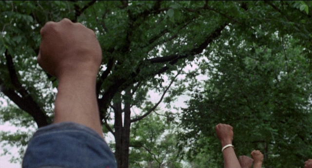 Wide shot frame from Medium Cool — hand, fight, person
