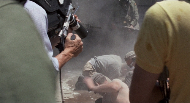 Wide shot frame from Medium Cool — smoke, person, human face